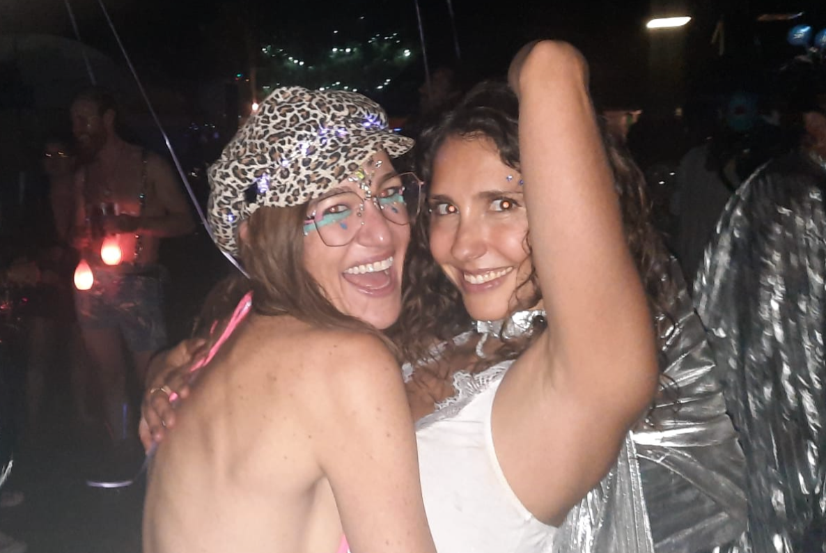 Two best friends laughing together at a nighttime event